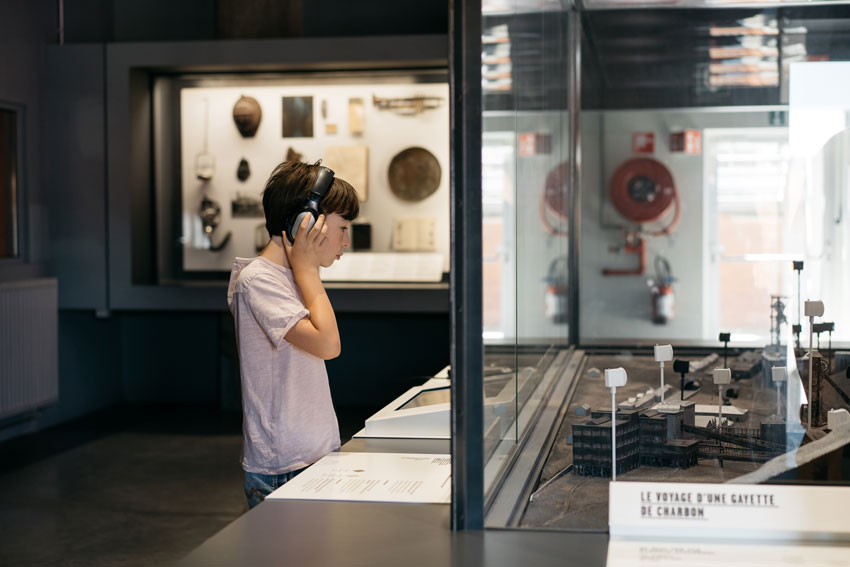 Enfant avec un casque devant la maquette charbonnage crachet au SPARKOH
