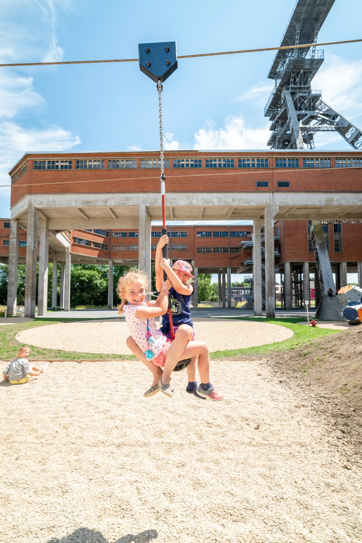 Petites filles sur tyrolienne de la plaine de jeux
