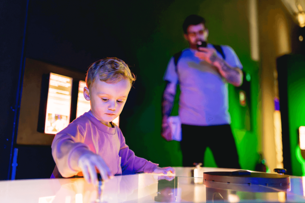 Kind en vader spelen met een lichtinstallatie