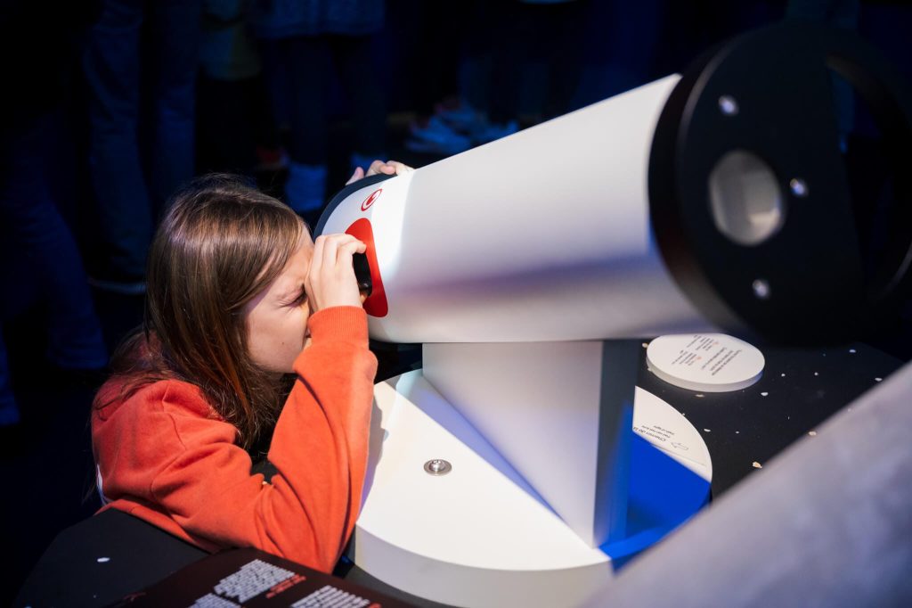 Expo COSMOS au SPARKOH! fille qui regarde au télescope